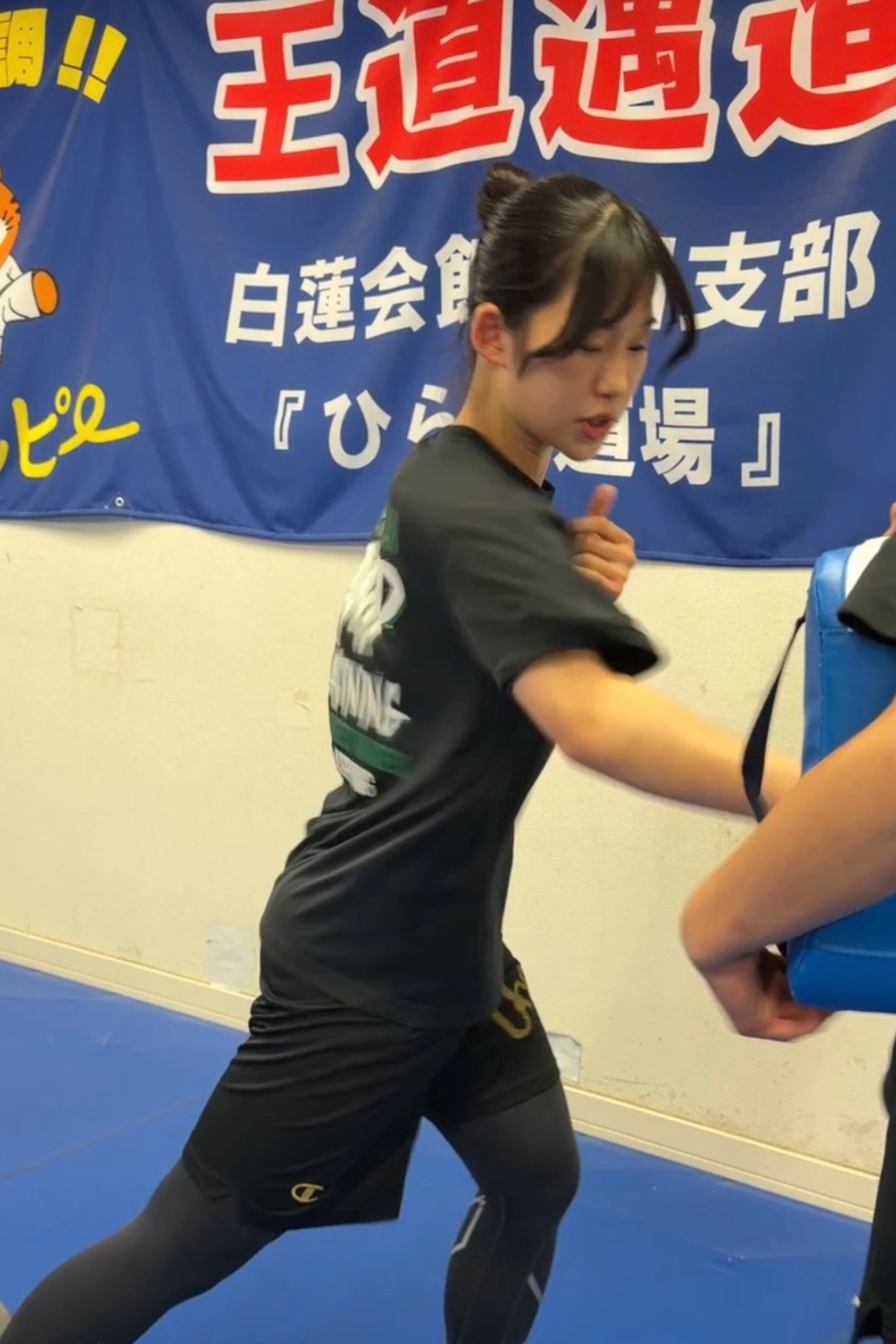 パーソナル指導で受講者がミットに突きを打ち込む練習風景